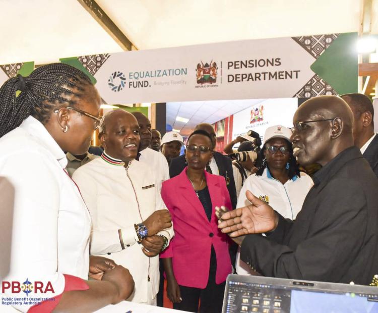 PS Immigration Dr. Belio Kipsang interacts with PBORA officers at the Authority's booth at Eldoret National Polytechnic during Mashujaa Thematic exhibition. 